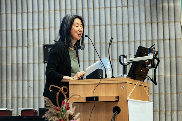 Dr. Karen Yoshida stands at a podium.