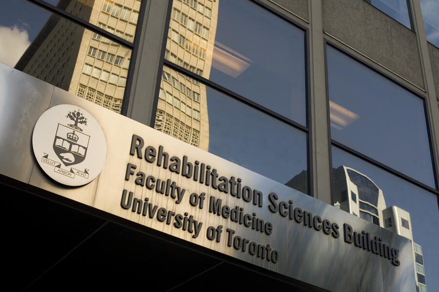 Picture of the sign on the outside of 500 University, with the University Crest on the left and Rehabilitation Sciences Building on the right