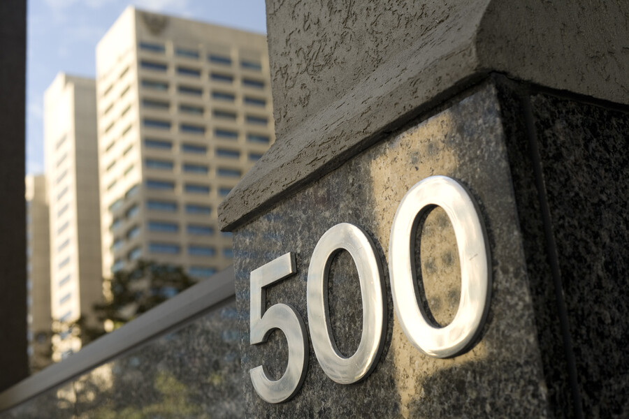 Close up of the 500 on the outside of the building with a grey building reflecting in the background