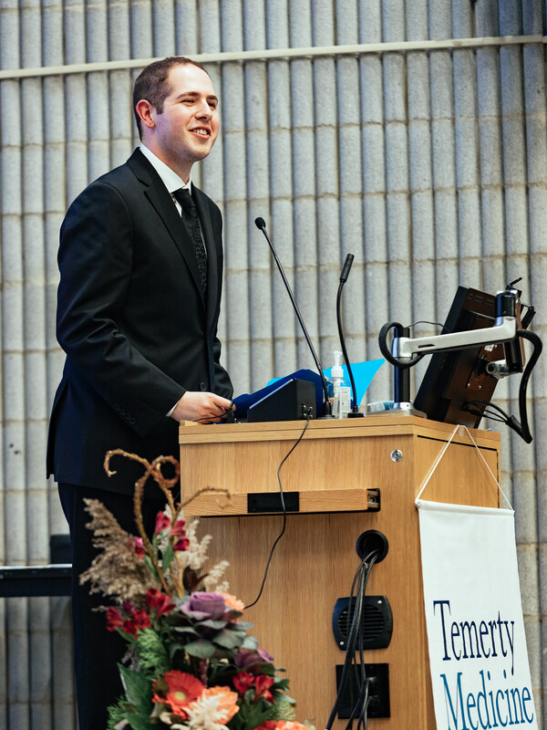 Corey Grunberg speaking at a podium.