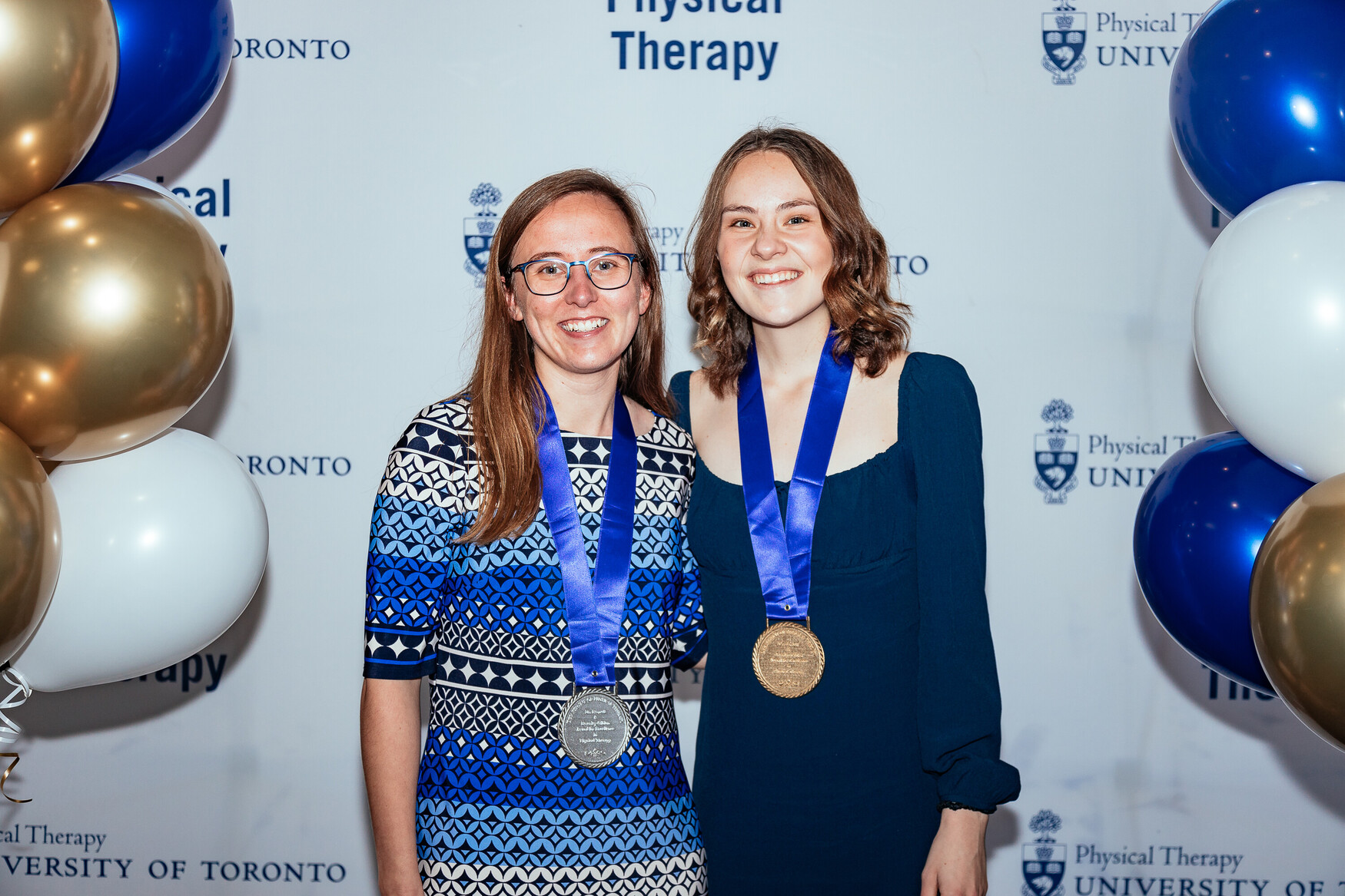 Mikaela Hummel and Claire Romani pose wearing their silver and gold medals, respectively.